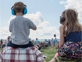 Adults and children watch aircraft perform at the Cold Lake Air Show on Sunday, July 22, 2018 after the weather cleared. An estimated 20,000 people attended the two-day show. Credit: