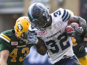 Toronto Argonauts running back James Wilder Jr. (right) is tackled by Edmonton Eskimos defensive back Neil King during the first half of CFL football action in Toronto on Sept. 16, 2017.