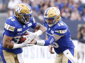 Winnipeg Blue Bombers quarterback Matt Nichols (15) hands off to Andrew Harris (33) during the first half of CFL action against the BC Lions in Winnipeg Saturday, July 7, 2018. THE CANADIAN PRESS/John Woods ORG XMIT: JGW101