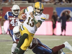 Edmonton Eskimos quarterback Mike Reilly evades a tackle during second half CFL football action against the Montreal Alouettes in Montreal, Thursday, July 26, 2018.