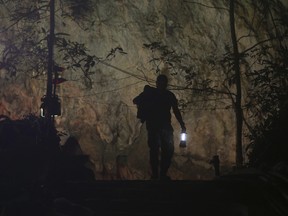 A rescuer makes his way down at the entrance to a cave complex where 12 boys and their soccer coach went missing, in Mae Sai, Chiang Rai province, in northern Thailand, Wednesday, July 4, 2018. (AP Photo/Sakchai Lalit)