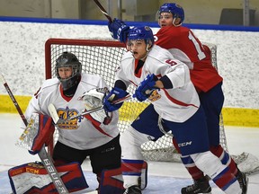 Edmonton Oil Kings Ty Gerla (12 red) and Jayden Platz (5) battle in front of goalie Colby Knight in the annual Red and White intrasquad game during training camp at the Downtown Community Arena in Edmonton, Aug. 29, 2018.