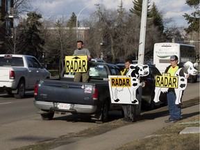 Members of the group Alberta Cash Cows warn motorists about a photo radar location along Whyte Avenue near 98 Street, in Edmonton Saturday April 29, 2017. Photo by David Bloom