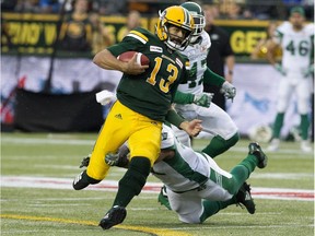 Edmonton Eskimos' Mike Reilly (13) runs the football for a first down during first half CFL action against the Saskatchewan Roughriders at Commonwealth Stadium, in Edmonton Thursday Aug. 2, 2018.