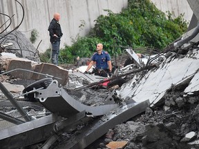 Rescues work among the debris of the collapsed Morandi highway bridge in Genoa, Tuesday, Aug. 14, 2018. Italian authorities say that about 10 vehicles were involved when the raised highway collapsed during a sudden and violent storm in the northern port city of Genoa, while private broadcaster Sky TG24 said the collapsed section was about 200-metre long (650 feet).