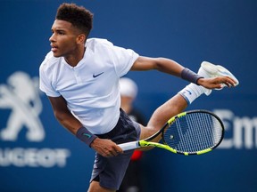 Felix Auger-Aliassime, of Canada, serves to Lucas Pouille, not shown, of France, during the first round of the Men's Rogers Cup tennis tournament in Toronto, Tuesday, August 7, 2018.