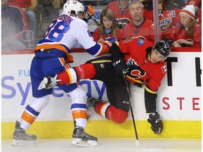 New York Islanders Brandon Davidson collides with Mikael Backlund of the Calgary Flames during NHL hockey at the Scotiabank Saddledome in Calgary on Sunday, March 11, 2018.