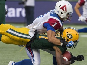 Edmonton Eskimos' Derel Walker s tackled  by Montreal Alouettes' Branden Dozier during CFL action in Edmonton on Aug. 18, 2018.