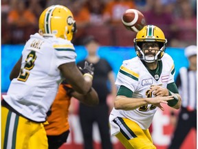 Edmonton Eskimos quarterback Mike Reilly, right, tosses the ball to C.J. Gable during second half CFL football action against the B.C. Lions, in Vancouver on Thursday, August 9, 2018.