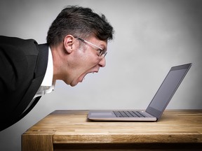 Man sitting at the table and screaming at his laptop