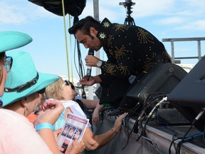 An Elvis tribute artist flirts with the audience at the Blue Suede Shoes Music Festival in Busby, Alta. The festival goes Friday to Sunday, Aug. 24-26, 2018.