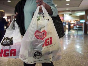 A woman leaves a grocery store Friday, May 15, 2015 in Montreal. Victoria is the latest Canadian city to move ahead with a ban on single-use plastic shopping bags.