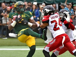 Edmonton Eskimos D'haquille Williams (81) makes a reception and scores a touchdown on Calgary Stampeders Tay Glover-Wright (24) and Emanuel Davis (8) during CFL action at Commonwealth Stadium in Edmonton, September 8, 2018.