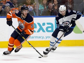 The Edmonton Oilers captain Connor McDavid (97) battles the Winnipeg Jets' Jacob Trouba (8) during second period pre-season NHL action at Rogers Place, Sept. 20, 2018.