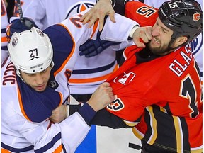 Edmonton Oilers Milan Lucic fights Tanner Glass of the Calgary Flames during NHL hockey at the Scotiabank Saddledome in Calgary on Saturday, March 31, 2018.