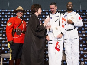 RCMP Sgt. Alexander DaSilva, left, and presiding official Elexis Schloss have their picture taken with new Canadian citizens Daniel Straka and husband Ali Finley, who dressed in NASA jumpsuits during a citizenship ceremony that featured Star Wars Storm Troopers at the Edmonton Expo Centre on Friday, Sept. 21, 2018 in Edmonton.