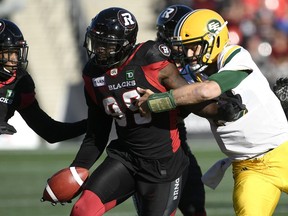 Ottawa Redblacks defensive lineman A.C. Leonard (99) fends off Edmonton Eskimos quarterback Mike Reilly (13) as he runs with the ball after recovering it from Eskimos running back C.J. Gable (2), not seen, during first half CFL football action in Ottawa on Saturday, Sept. 22, 2018.