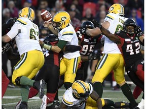 Edmonton Eskimos quarterback Mike Reilly (13) loses control of the ball as he is sacked by Ottawa Redblacks linebacker Kyries Hebert (34) during second half CFL football action in Ottawa on Saturday, Sept. 22, 2018.