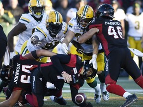 Ottawa Redblacks quarterback Trevor Harris (7) gets sacked as fullback Jean-Christophe Beaulieu (46) tries to push back Edmonton Eskimos linebacker Adam Konar (38) and defensive tackle Almondo Sewell (90) during second half CFL football action in Ottawa on Saturday, Sept. 22, 2018.