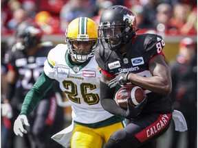 Edmonton Eskimos' Chris Edwards, left, chases Calgary Stampeders' DaVaris Daniels, as he scores a touchdown during first half CFL football action in Calgary, Monday, Sept. 3, 2018.