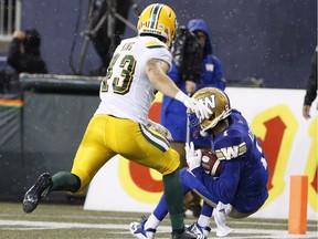 Winnipeg Blue Bombers' Darvin Adams (1) catches the touchdown pass as Edmonton Eskimos' Neil King (43) defends during the first half of CFL action in Winnipeg Thursday, June 14, 2018.