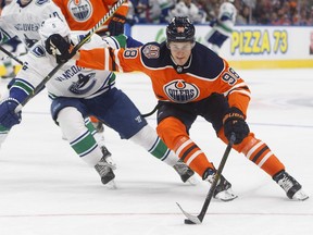 Vancouver Canucks' Derrick Pouliot (5) chases Edmonton Oilers' Jesse Puljujarvi (98) during second period pre-season action in Edmonton, Alta., on Tuesday September 25, 2018.