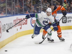 Vancouver Canucks' Brendan Leipsic (9) and Edmonton Oilers' Evan Bouchard (75) battle for the puck during first period pre-season action in Edmonton, Alta., on Tuesday September 25, 2018.