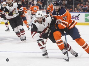 Arizona Coyotes defenceman Jason Demers, left, and Edmonton Oilers forward Tobias Rieder battle for the puck on Sept. 27, 2018, during NHL preseason action in Edmonton.