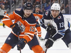 Edmonton Oilers defenceman Jakub Jerabek, left, battles Winnipeg Jets' Brandon Tanev for the puck during NHL pre-season action in Edmonton on Sept. 20, 2018.