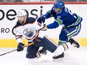 Vancouver Canucks defenseman Troy Stecher (51) fight for control of the puck with Edmonton Oilers Josh Currie during first period NHL pre-season action at Rogers Arena in Vancouver, Tuesday, Sept, 18, 2018.