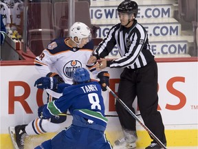 Vancouver Canucks defenseman Christopher Tanev (8) goes into the boards with Edmonton Oilers center Ryan Strome (18) during first period NHL pre-season action at Rogers Arena in Vancouver, Tuesday, Sept, 18, 2018.