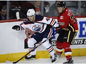 Edmonton Oilers Pontus Aberg, left, and Calgary Flames' Kerby Rychel tangle during preseason NHL hockey action in Calgary, Monday, Sept. 17, 2018.