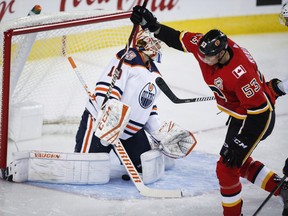 Edmonton Oilers' goalie Mikko Koskinen, left, reacts as Calgary Flames' Buddy Robinson celebrates a goal during first period preseason NHL hockey action in Calgary, Monday, Sept. 17, 2018.