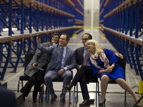 Ivonne Martinez, President, Alberta Store Association, leans over as Alain Maisonneuve, President & CEO AGLC takes a selfie with Joe Ceci Minister of Finance and Cathy Heron, mayor of St. Albert after the opening the new liquor distribution centre on Wednesday, Sept. 19, 2018 in St Albert.  (Greg  Southam - Postmedia)