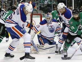 Edmonton Oilers' Adam Larsson (6) and Oscar Klefbom (77) of Sweden help Cam Talbot (33) clear a puck away from the net under pressure from Dallas Stars' Patrick Eaves (18) in the first period of an NHL hockey game, Saturday, Nov. 19, 2016, in Dallas.