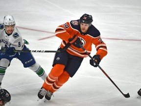 Edmonton Oilers Leon Draisaitl (29) gets hooked by Vancouver Canucks Brendan Leipsic (9) during NHL pre-season action at Rogers Place in Edmonton, September 25, 2018. Ed Kaiser/Postmedia