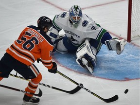 Edmonton Oilers forward Kailer Yamamoto trie to get the puck past Vancouver Canucks goalie Anders Nilsson during NHL pre-season action on Sept. 25, 2018, at Edmonton's Rogers Place.