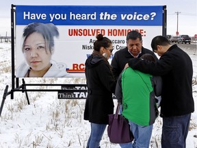 Vivian Tuccaro, back turned, is consoled by, left to right, Judy Anne Cardinal, Chief Steve Courtoreille of the Mikisew Cree First Nations of Fort Chipewyan and her son Paul Tuccaro at the 2013 unveiling of a billboard seeking information about homicide victim Amber Tuccaro at the intersection of Highway 814 and Airport Road east of Nisku, Alta.