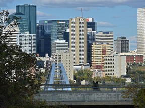 Pedestrains cross a bridge on Saskatachewan Dr. overlooking the Walterdale Bridge and downtown Edmonton, September 19, 2018.