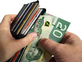 The action of pulling canadian money out of a wallet. ORG XMIT: POS1610071939292809