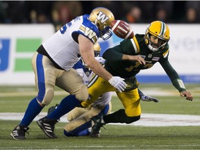 Edmonton Eskimos quarterback Mike Reilly (13) is sacked by members of the Winnipeg Blue Bombers during second half CFL action on Saturday, Sept. 29, 2018 in Edmonton.