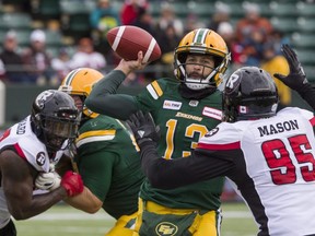 Edmonton Eskimos quarterback Mike Reilly gets the ball out under pressure from Ottawa RedBlacks Danny Mason (95) during first half CFL action in Edmonton on Saturday, Oct. 13, 2018.