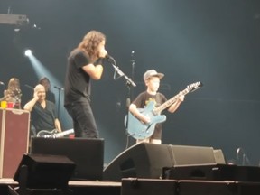 Foo fighters fan Collier Cash Rule, right, joins the band's frontman Dave Grohl onstage to play a few chords of Metallica’s Enter Sandman during the Foo fighters' concert in Kansas City. (YouTube)