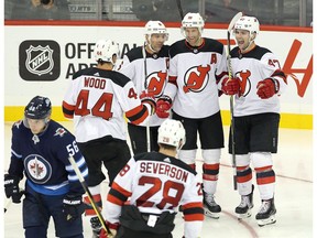 New Jersey Devils forward Miles Wood (44), defenceman Andy Greene (6), forward Travis Zajac (19) and forward John Quenneville (47) celebrate Zajac's goal against the Winnipeg Jets during third period NHL pre-season game action in Winnipeg, Thursday, September 27, 2017.