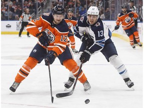 Winnipeg Jets' Brandon Tanev (13) and Edmonton Oilers' Jakub Jerabek (12) battle for the puck during first period pre-season action in Edmonton on Thursday September 20, 2018.