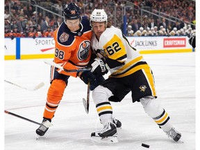 Edmonton Oilers forward Jesse Puljujarvi (98) battles against Pittsburgh Penguins' Carl Hagelin (62) during first period NHL action in Edmonton on Tuesday, Oct. 23, 2018.