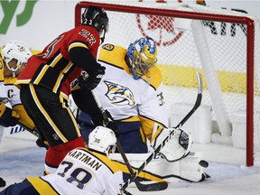 Nashville Predators goalie Pekka Rinne, right, of Finland, kicks the puck aay on a shot from Calgary Flames' Sean Monahan during NHL hockey action in Calgary, Friday, Oct. 19, 2018.THE CANADIAN PRESS/Jeff McIntosh ORG XMIT: JMC109