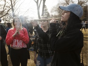 Revelers smoke a big joint during the 4-20 marijuana rally at the Alberta legislature in Edmonton on April 20, 2018.