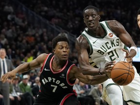 The Bucks’ Tony Snell (right) tries to drive past Toronto Raptors guard Kyle Lowry last night in Milwaukee. (AP)