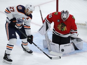 Chicago Blackhawks' Cam Ward, right, makes a save against Edmonton Oilers' Milan Lucic, Sunday, Oct. 28, 2018, in Chicago.